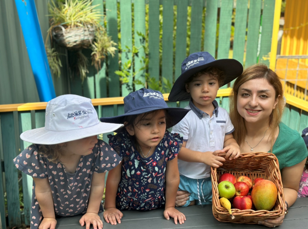 childcare centre lanecove where 3 children are with a teacher holding fruits